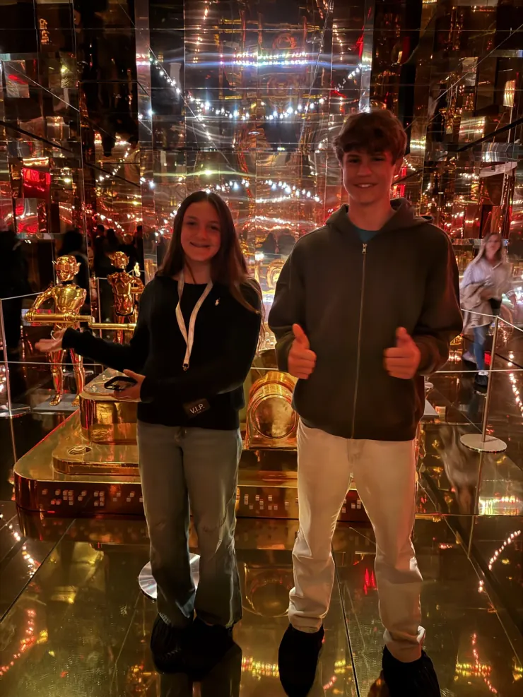 Ruby in a mirrored room of gold statues and lights
