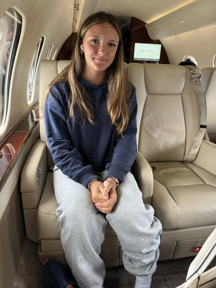 Ruby sitting in a small plane's cabin seat before take-off