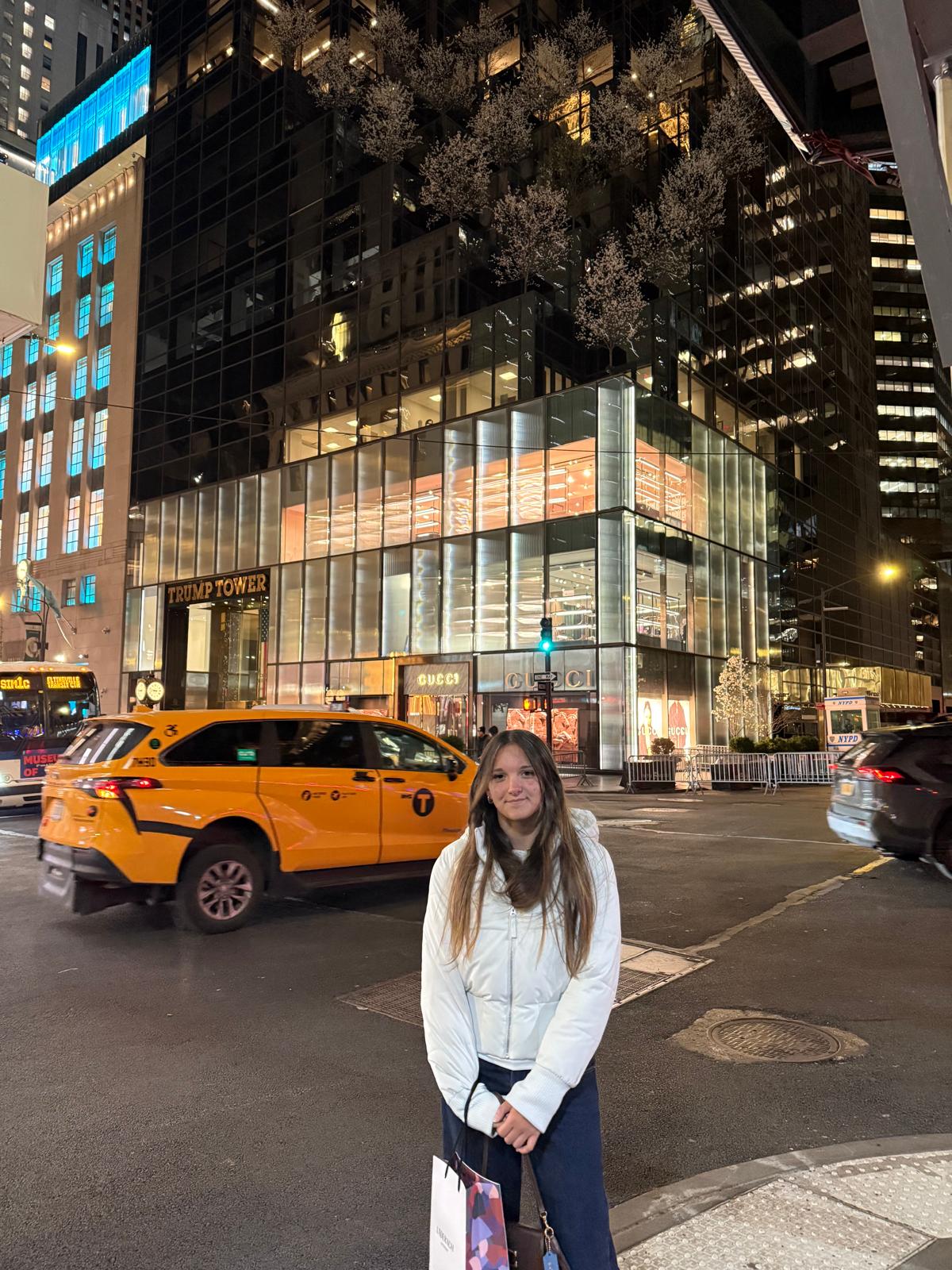 Ruby on a New York street at night, yellow cab behind her