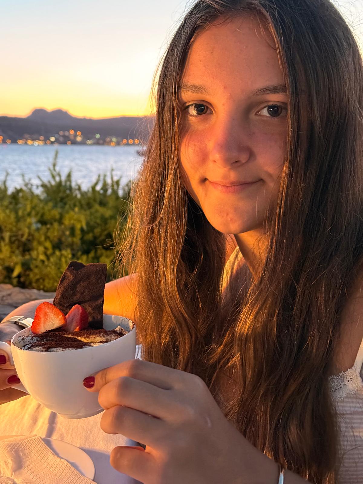 Ruby at golden hour by the sea, dessert in hand